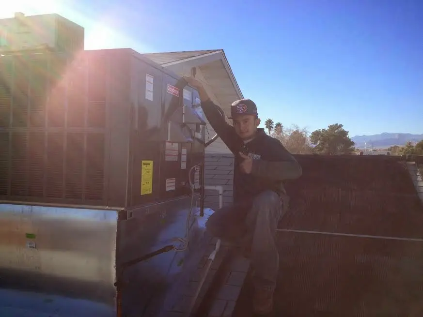 HVAC technician performing AC Tune-Up on a rooftop unit in Ridgeland
