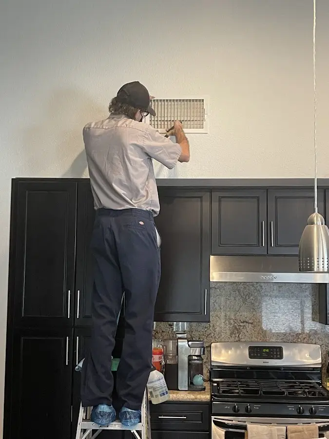 Technician inspecting an air vent during HVAC service in Ridgeland